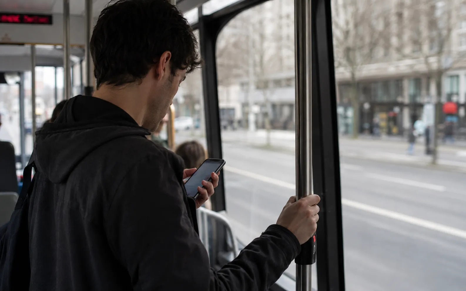Someone practising on their phone while standing on a bus